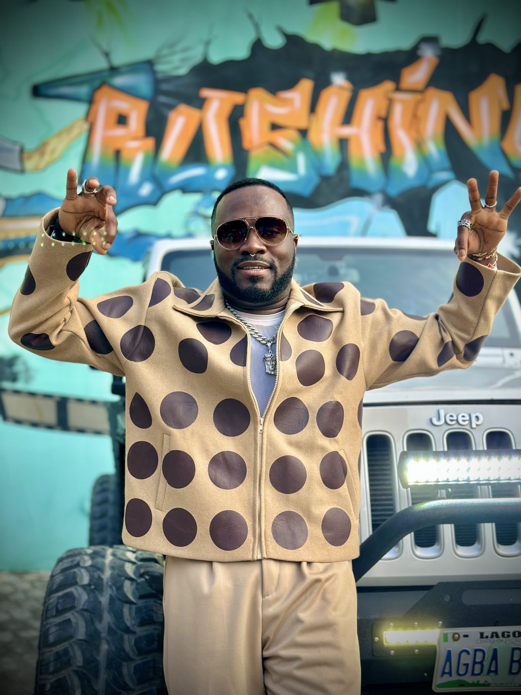 Don Crucifixto throwing peace signs beside the Lagos Jeep