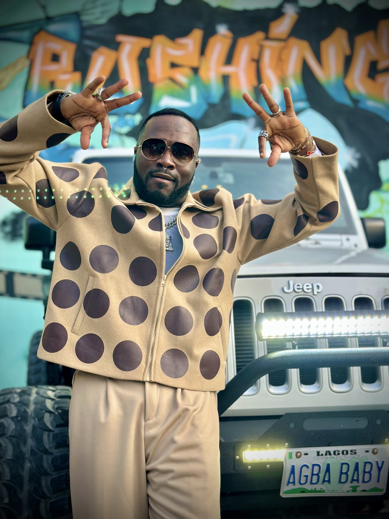Don Crucifixto in a polka-dot suit beside a custom Jeep